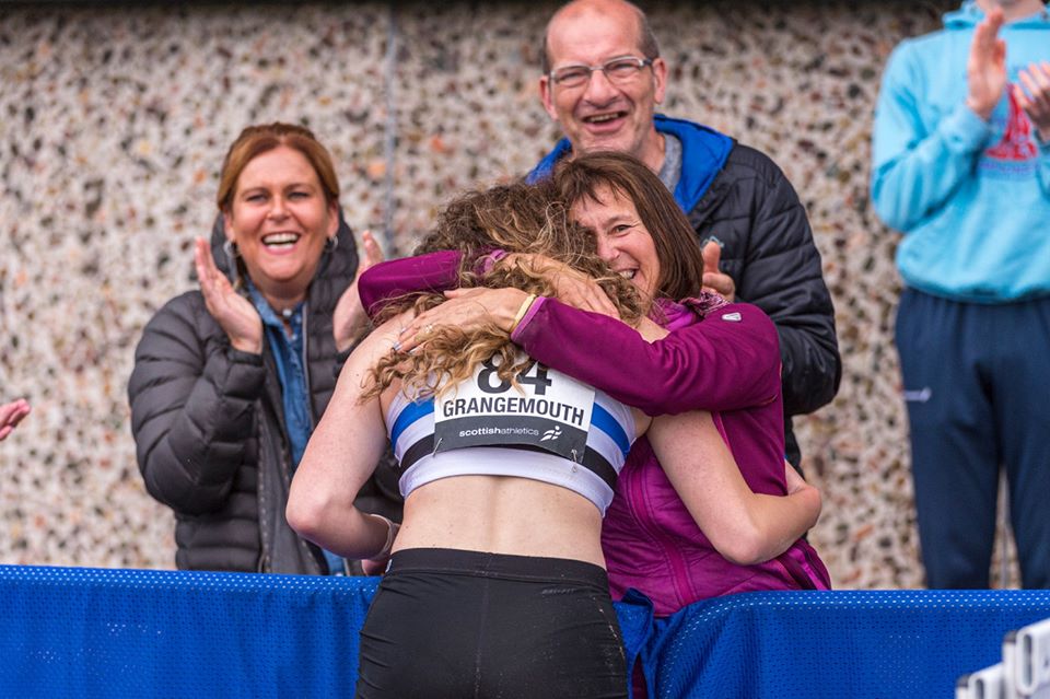 Woman hugging female athlete at event